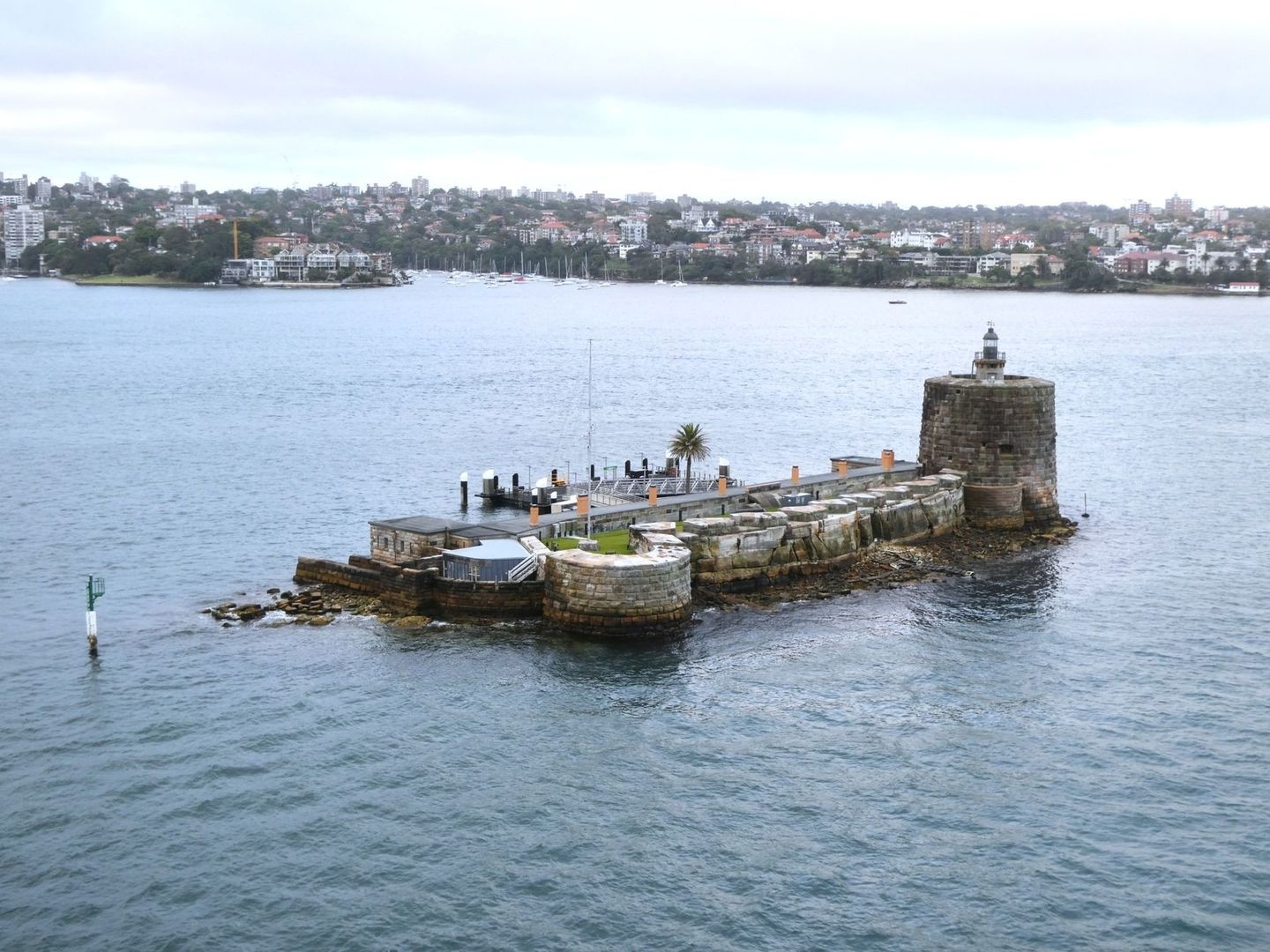 Stone waterfront fort with lighthouse beside Sydney Harbour